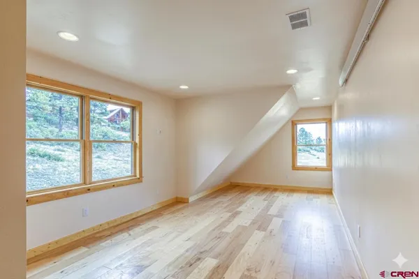 a view of empty room with wooden floor