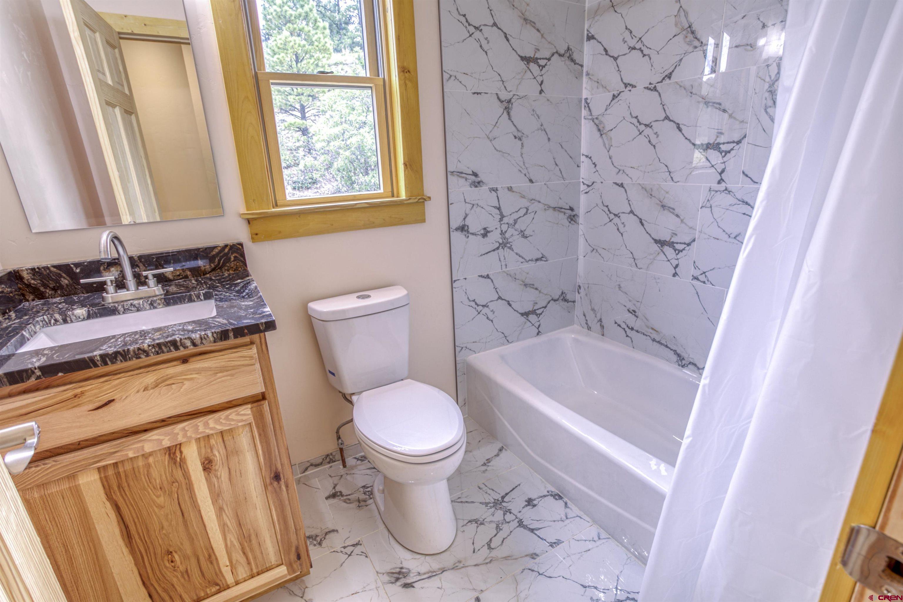 159 Snow Circle Pagosa Springs, CO 81147 - Photo 34 of 45 a bathroom with a granite countertop sink toilet and shower