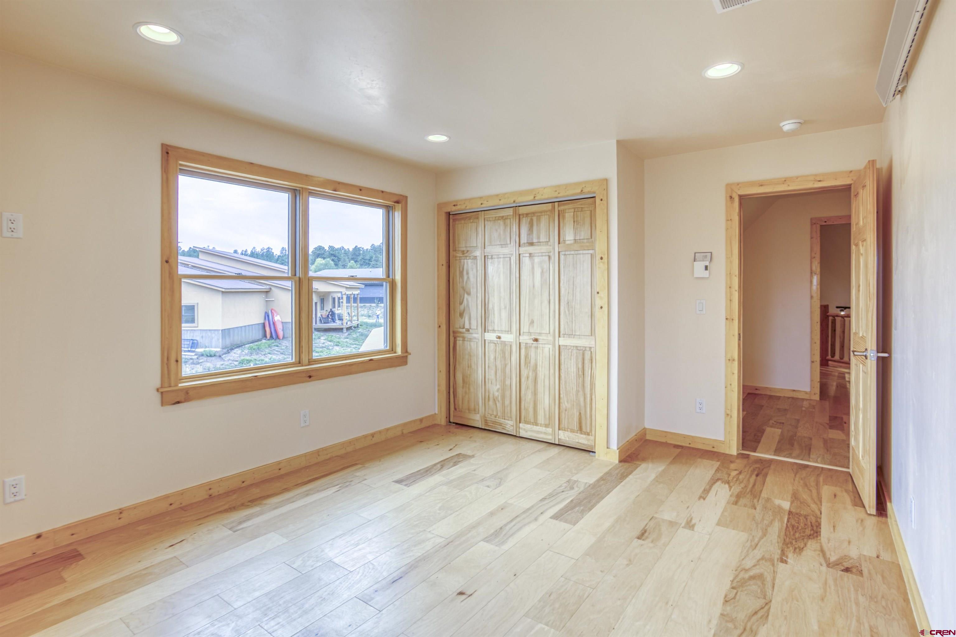 159 Snow Circle Pagosa Springs, CO 81147 - Photo 37 of 45 an empty room with wooden floor and windows