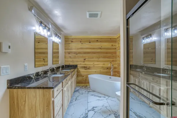 a bathroom with a granite countertop sink a mirror and a bathtub