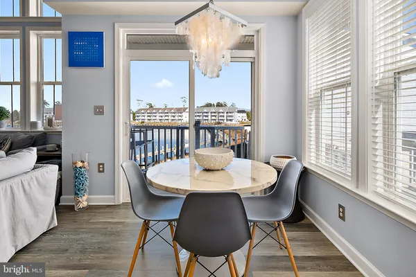 a kitchen with stainless steel appliances granite countertop a dining table chairs refrigerator and cabinets