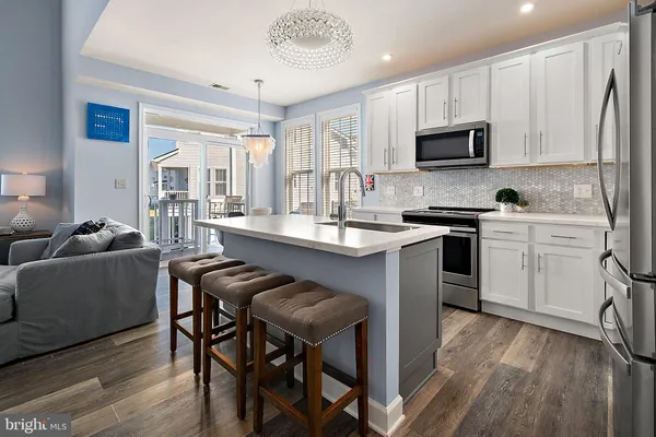 a kitchen with stainless steel appliances a refrigerator microwave and sink