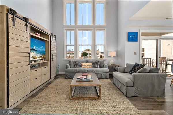 a living room with furniture a rug and a large window