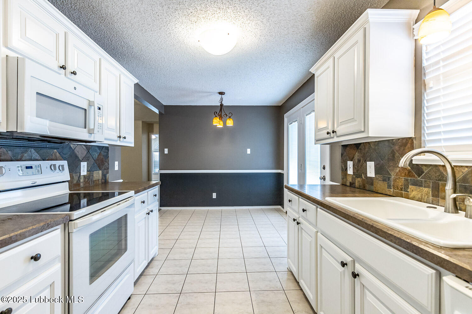 6120 7th Drive Lubbock, TX 79416 - Photo 15 of 33 a kitchen with stainless steel appliances granite countertop a sink and cabinets