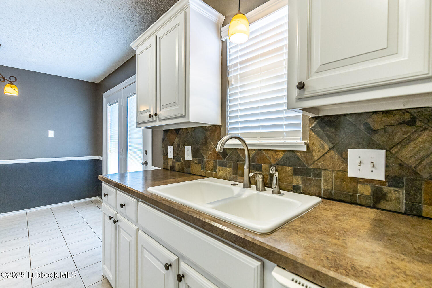 6120 7th Drive Lubbock, TX 79416 - Photo 16 of 33 a kitchen with stainless steel appliances granite countertop a sink and a white cabinets