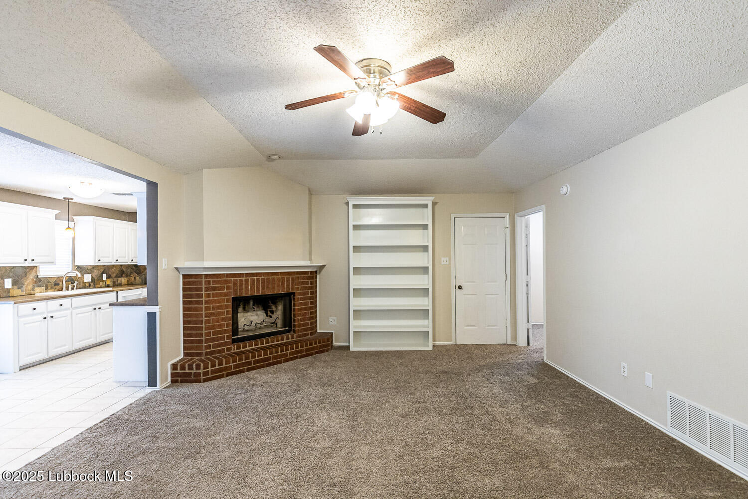 6120 7th Drive Lubbock, TX 79416 - Photo 7 of 33 a big room with chandelier and fireplace