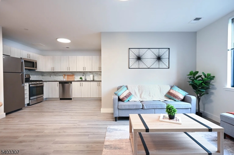49 South Day Street, Unit 316 Orange, NJ 07050 - Photo 5 of 26 a living room with stainless steel appliances furniture and a kitchen view