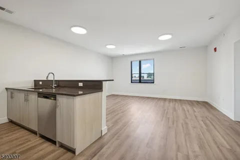 a kitchen with a sink and wooden floor