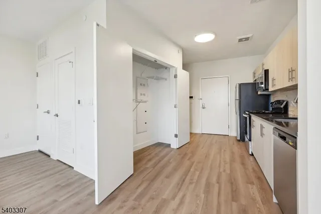a kitchen with cabinets and wooden floor