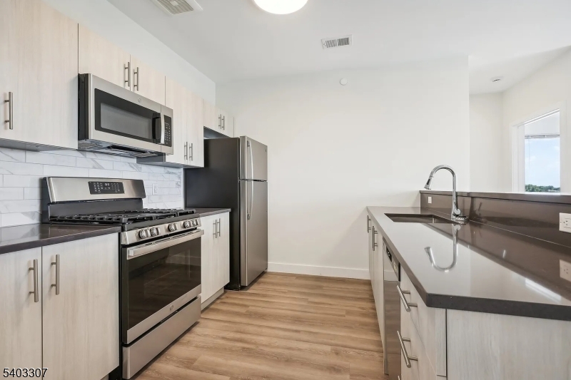 49 South Day Street, Unit 316 Orange, NJ 07050 - Photo 9 of 26 a kitchen with stainless steel appliances a stove microwave and sink