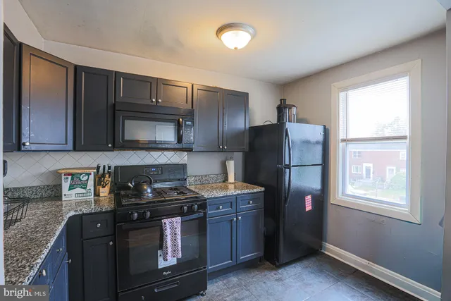 a kitchen with stainless steel appliances granite countertop a stove a refrigerator and a microwave