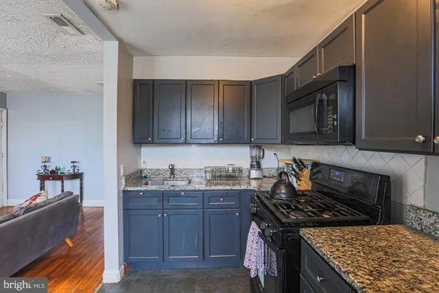 a kitchen with granite countertop a stove and a sink