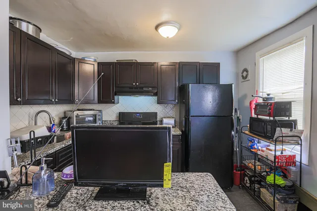 a kitchen with a refrigerator and a stove top oven