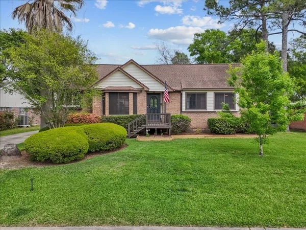 a front view of a house with a yard and potted plants