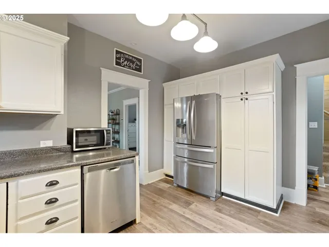 a kitchen with cabinets stainless steel appliances and a counter space