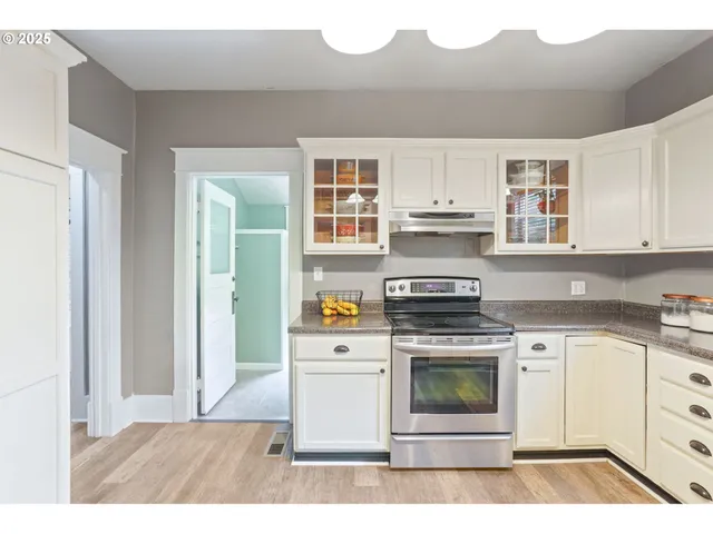 a kitchen with a stove top oven and cabinets