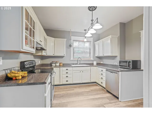 a kitchen with stainless steel appliances granite countertop a stove sink and cabinets