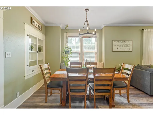 a view of a dining room with furniture a chandelier and wooden floor