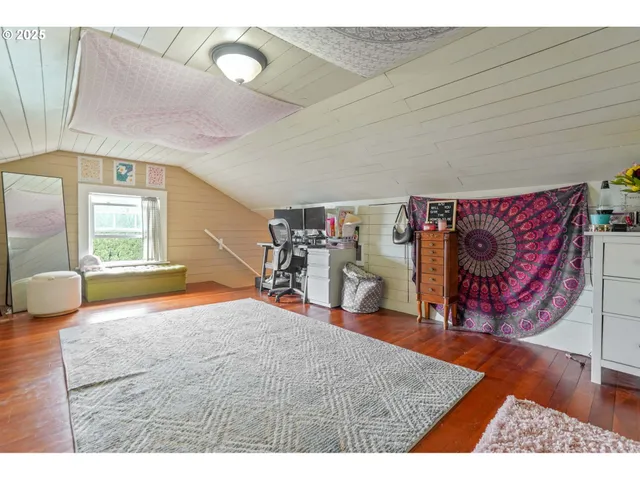 a view of a backyard with table and chairs and potted plants and large tree