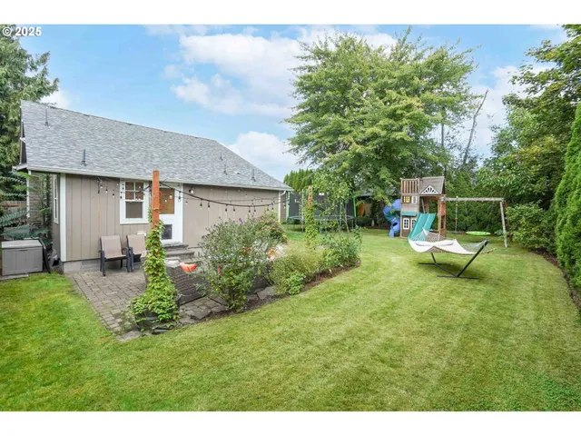 a view of a chair and table in backyard of the house