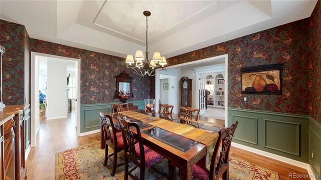 a view of a dining room with furniture a chandelier and wooden floor