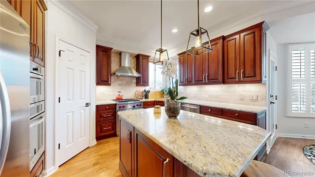 a kitchen with stainless steel appliances granite countertop a refrigerator a sink dishwasher and wooden cabinets with wooden floor