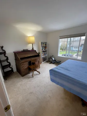 a bedroom with a bed and a dresser next to a window