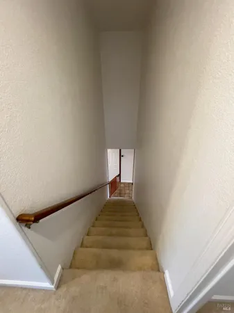 a view of a hallway with wooden staircase