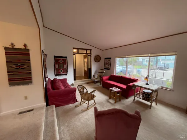 a living room with furniture a flat screen tv and a window