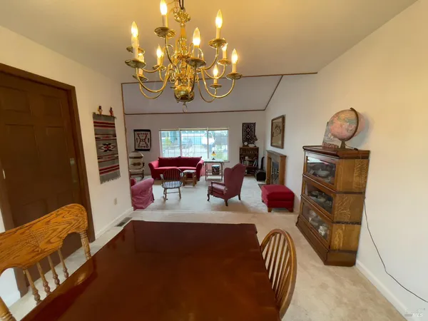 a view of a dining room with furniture a chandelier and wooden floor