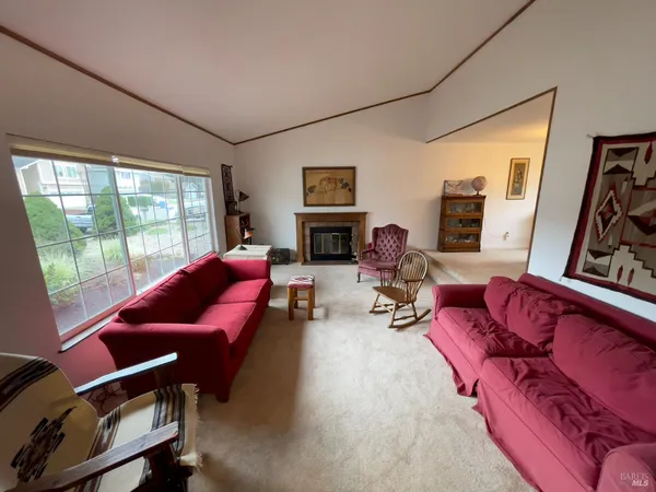 a living room with furniture fireplace and a large window