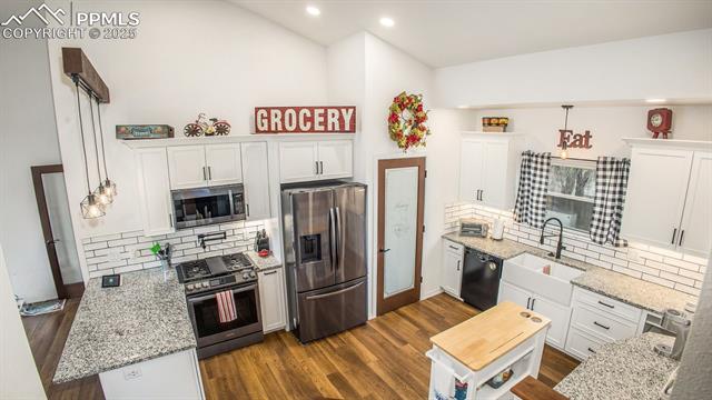 5085 Victory Road Colorado Springs, CO 80911 - Photo 13 of 18 Updated kitchen featuring granite countertops, a stylish subway tile backsplash, stainless steel appliances, and a gas range