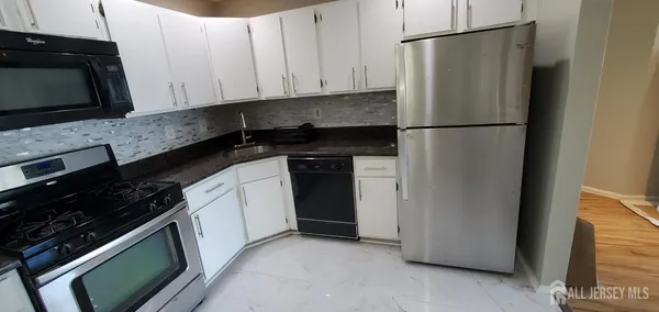 a kitchen with a refrigerator stove and microwave