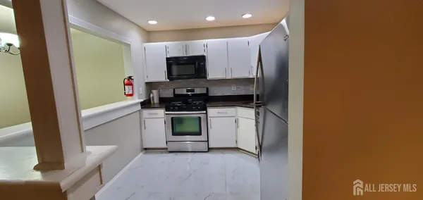 a kitchen with stainless steel appliances a stove a microwave and a refrigerator