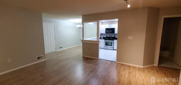 a view of a kitchen with wooden floor and electronic appliances