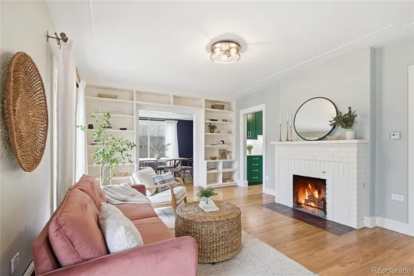 a living room with furniture a fireplace and a large window