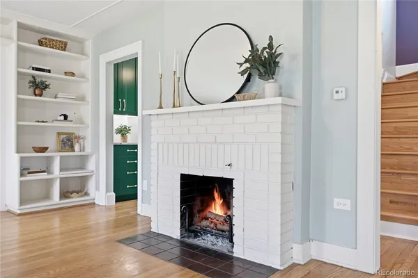 a view of a livingroom with wooden floor and a fireplace