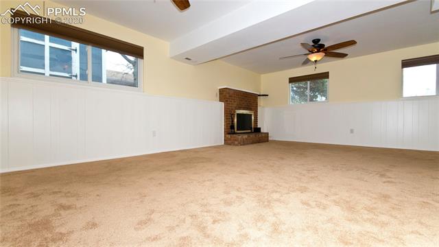4027 Maxwell Road Colorado Springs, CO 80909 - Photo 15 of 35 Lower level family room with brick wood burning fireplace.