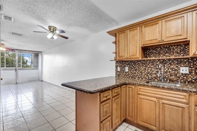 a kitchen with granite countertop a sink cabinets and window