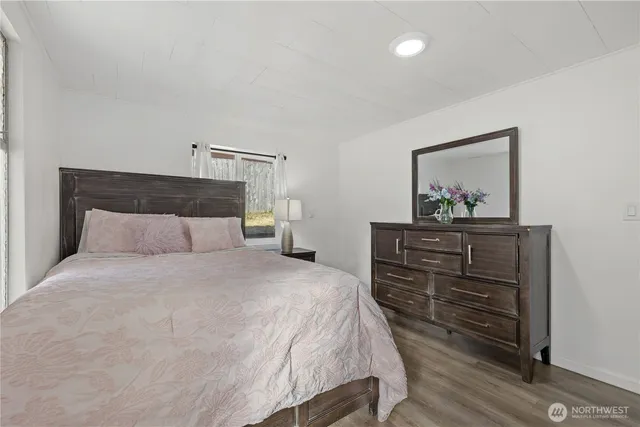 a bedroom with a bed and painting on the wall