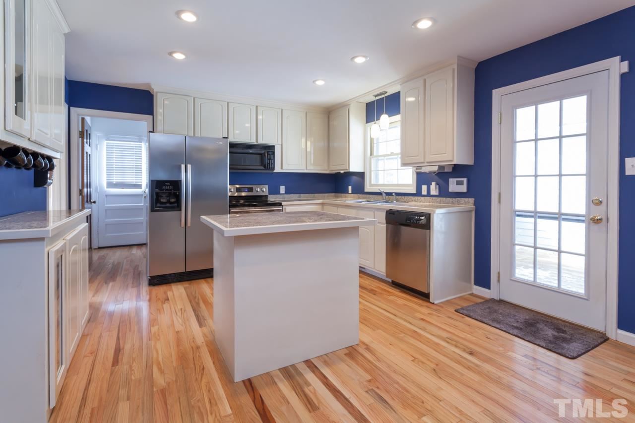 927 Winona Road Raleigh, NC 27609 - Photo 4 of 16 a kitchen with stainless steel appliances granite countertop a stove a sink dishwasher a refrigerator and a microwave oven with wooden floor