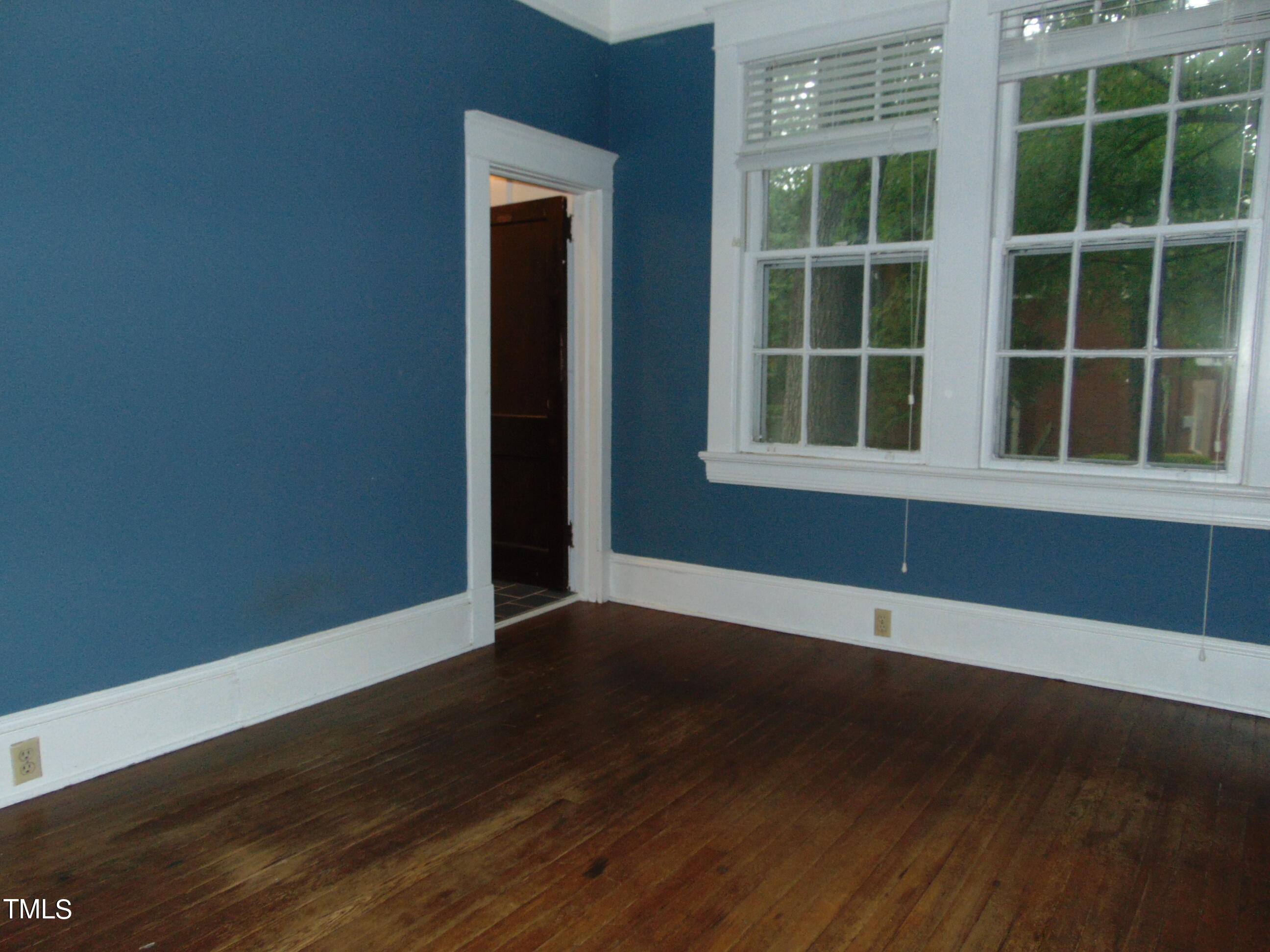 215 Woodburn Road Raleigh, NC 27605 - Photo 15 of 58 a view of an empty room with wooden floor and windows