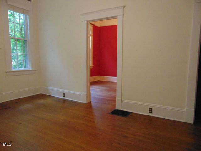 a view of a hallway with wooden floor and entryway