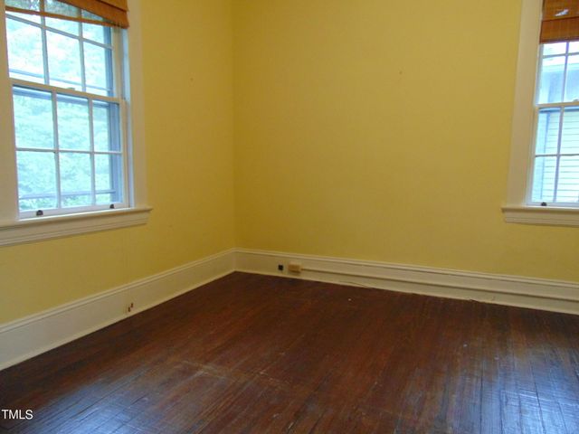 an empty room with wooden floor and closet