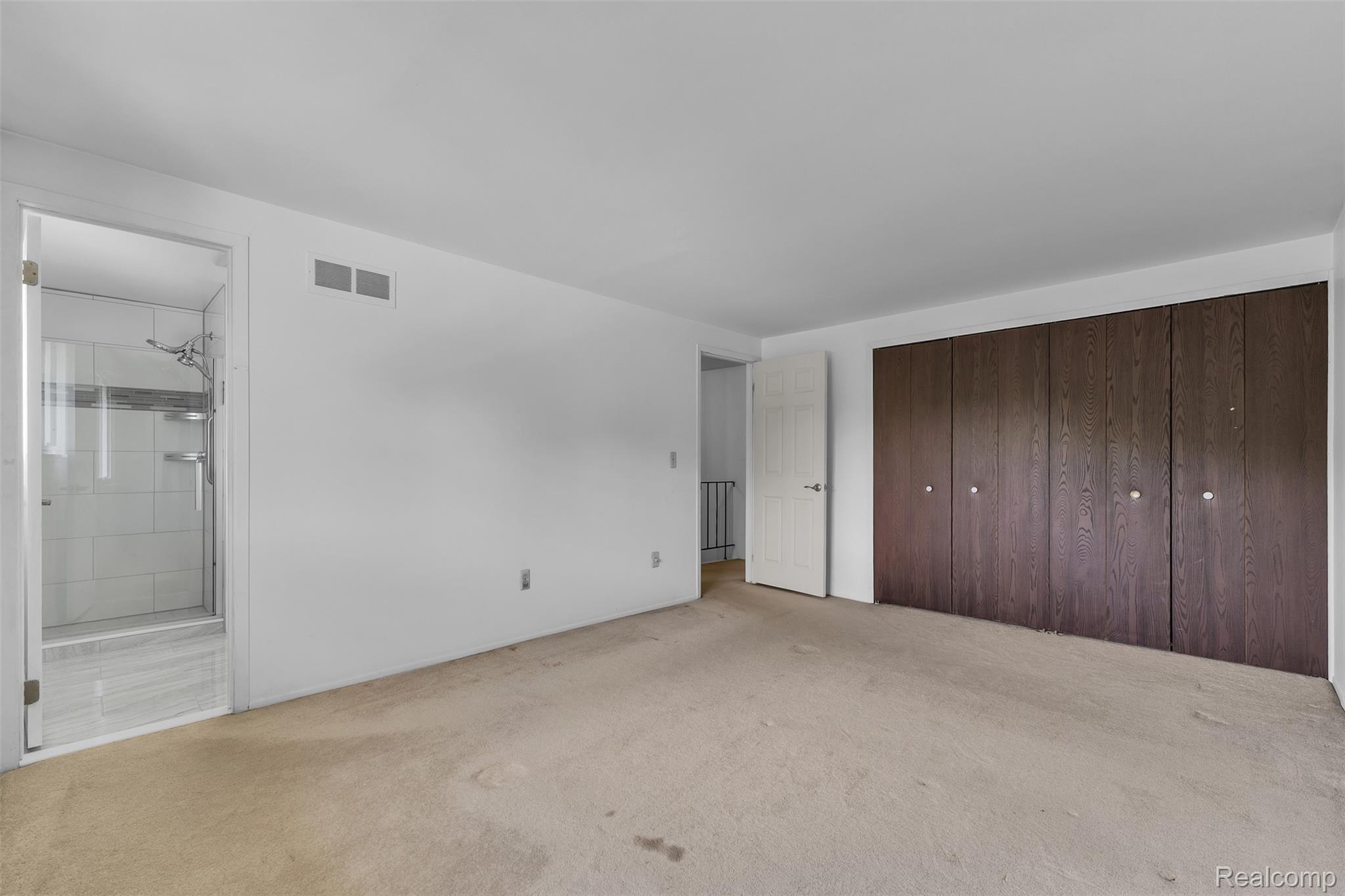 7000 Woonsocket Street Canton, MI 48187 - Photo 44 of 65 Expansive room featuring a wall of built-in dark wood-finish cabinetry, neutral-toned carpet, and a full bathroom with a glass-enclosed shower