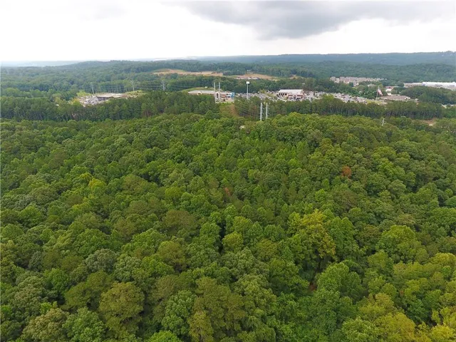 an aerial view of residential houses with outdoor space and trees