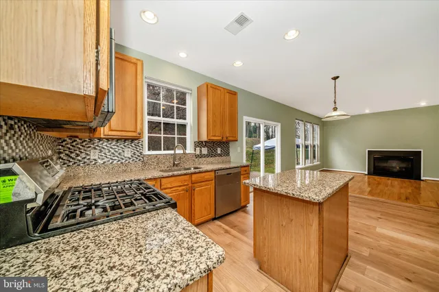 a kitchen with stainless steel appliances granite countertop a stove a sink and a refrigerator