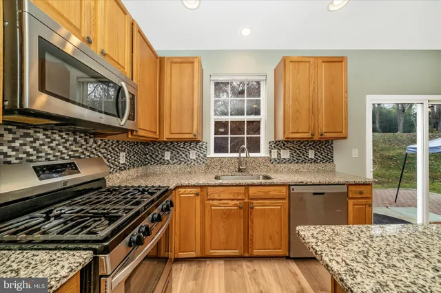 a kitchen with granite countertop a stove and a sink