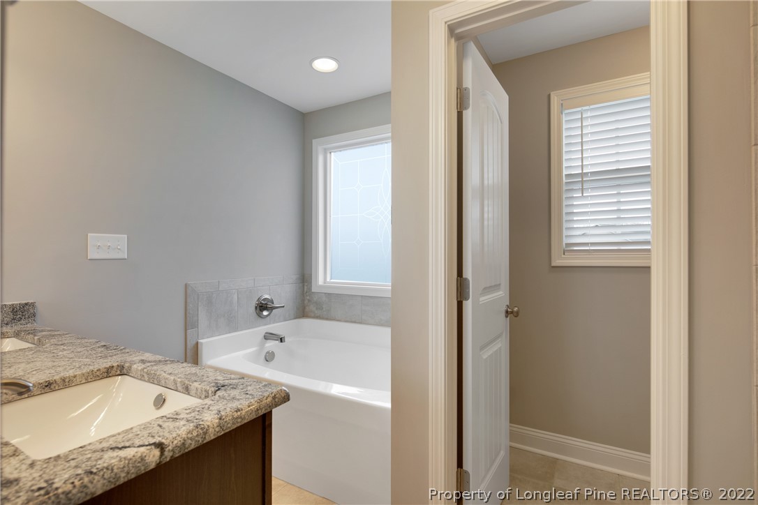 2643 Riddle Farm Hope Mills, NC 28348 - Photo 35 of 50 a bathroom with a granite countertop bathtub and a sink