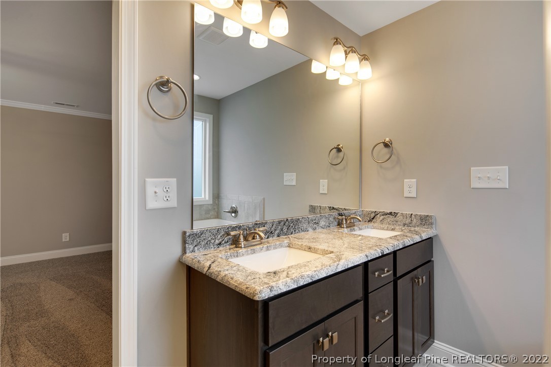 2643 Riddle Farm Hope Mills, NC 28348 - Photo 36 of 50 a bathroom with a granite countertop sink a light fixture and a mirror